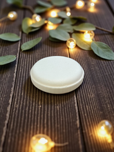 Load image into Gallery viewer, Light orange eucalyptus shower steamers arranged on a wooden table, with a natural, spa-like aesthetic