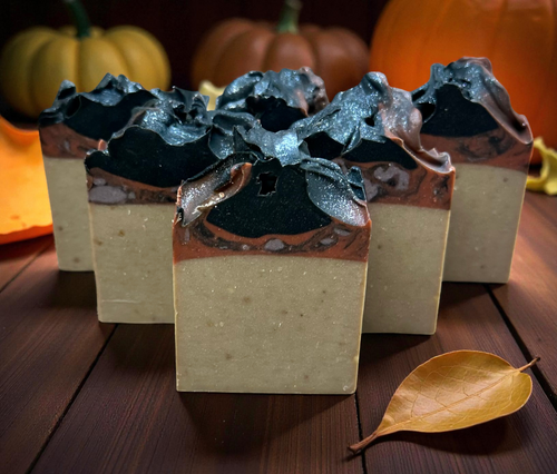 Handmade Pumpkin Apple Butter Soap with black swirls and fall pumpkins in the background