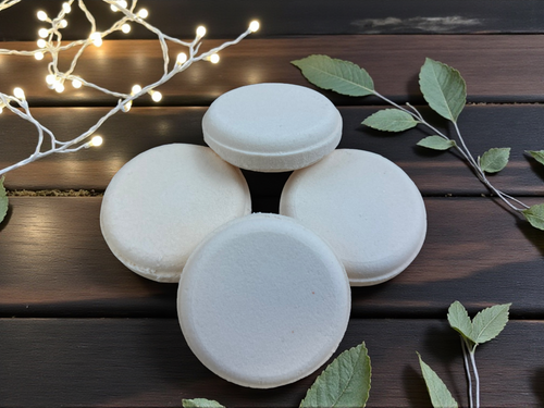 Light orange eucalyptus shower steamers arranged on a wooden table, with a natural, spa-like aesthetic